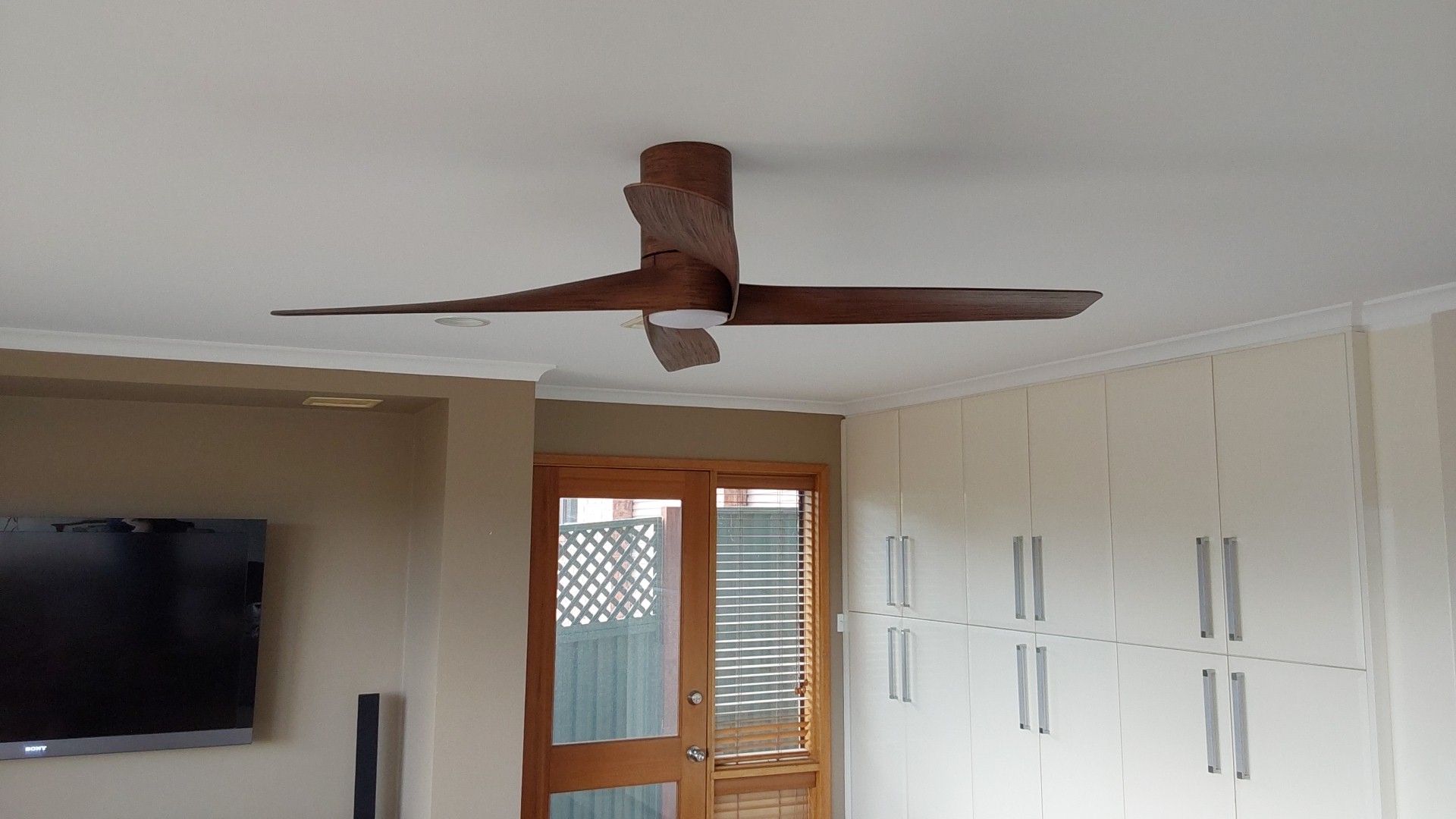 A timber-look ceiling fan with a built-in light, installed in a family room